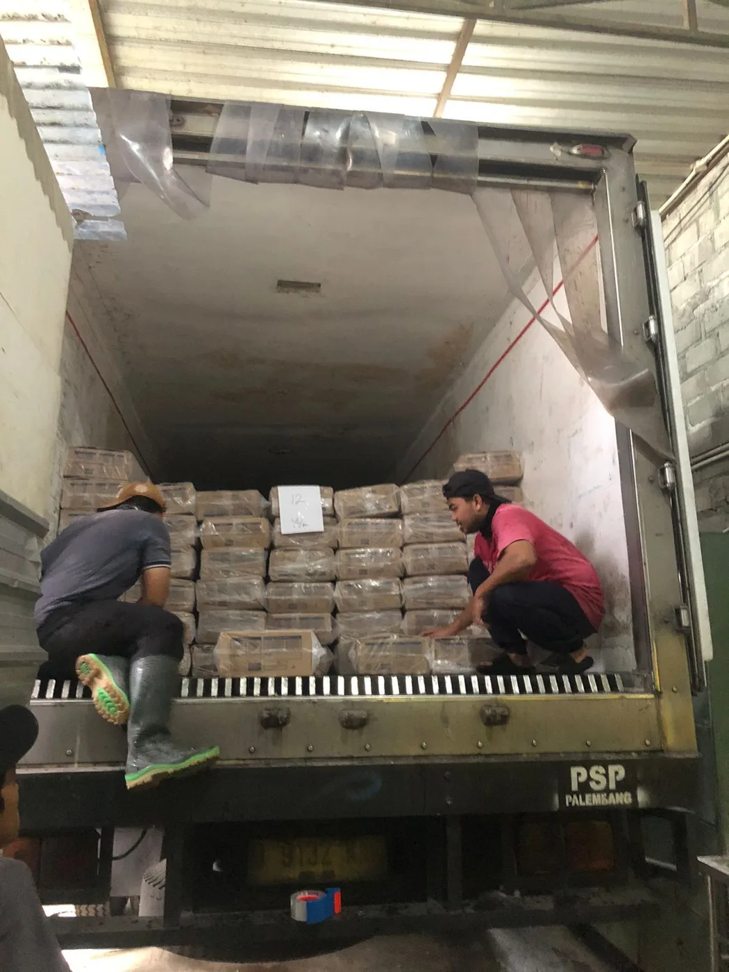 Staff loading cartons into a reefer truck